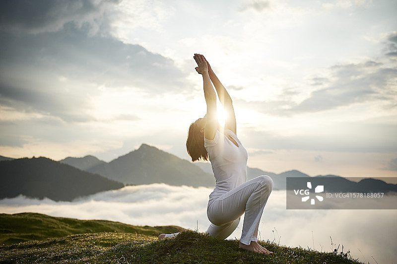 奥地利克兰茨峰中年女子在山顶练习瑜伽图片素材