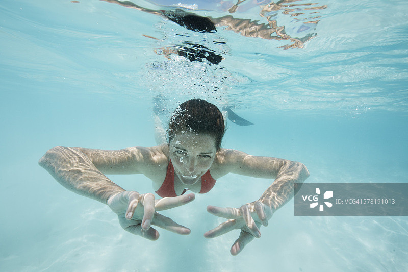 马尔代夫，快乐的女人在印度洋中游泳图片素材
