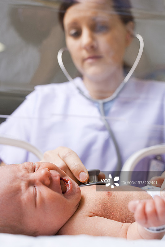 护士在保温箱中检查新生儿图片素材