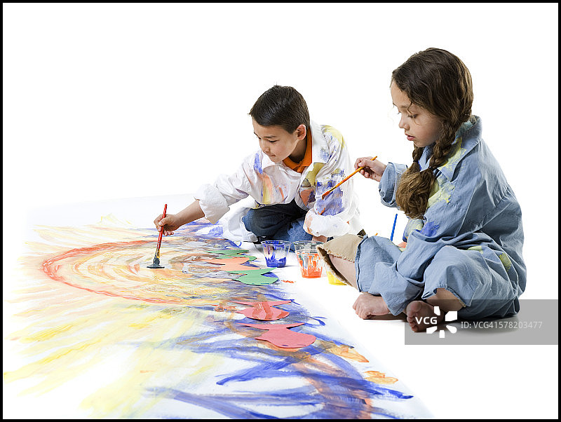 女孩和她的哥哥在地上绘画图片素材