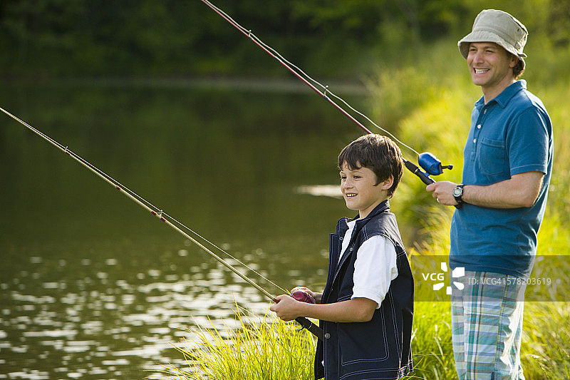 男子和儿子钓鱼的侧面照图片素材