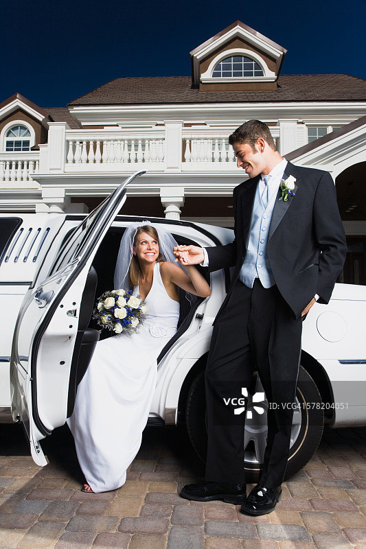 年轻男人牵着新娘的手下车图片素材