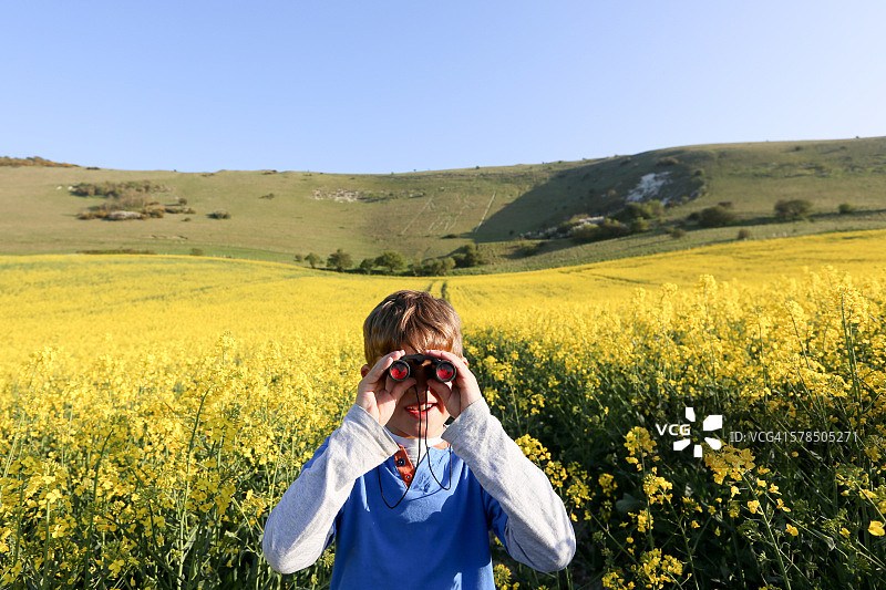 男孩使用双筒望远镜观看图片素材