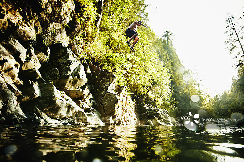 青少年男孩跳入河中图片素材