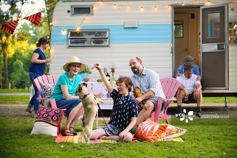 可爱的男孩和巴哥犬与家人朋友一起复古露营图片素材