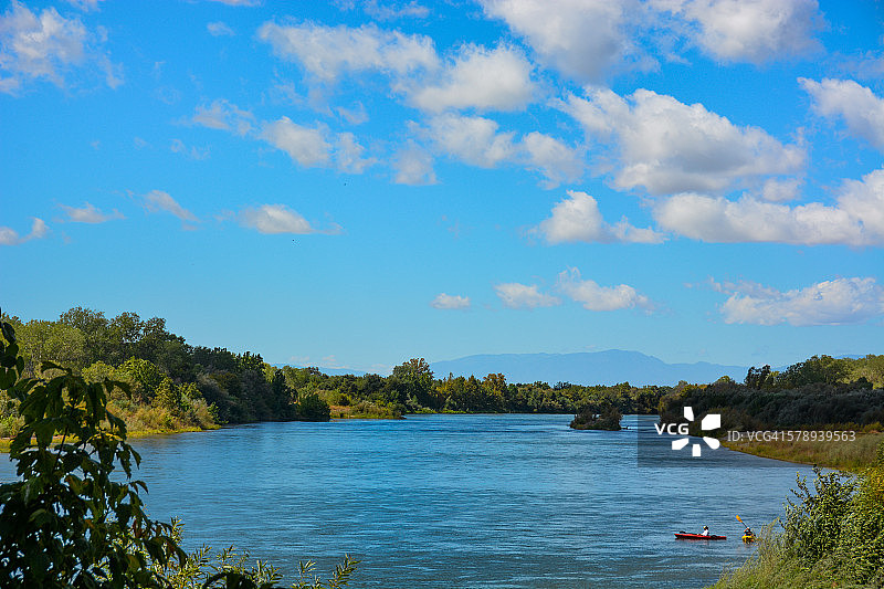 蓝天白云下河流上的皮划艇爱好者图片素材