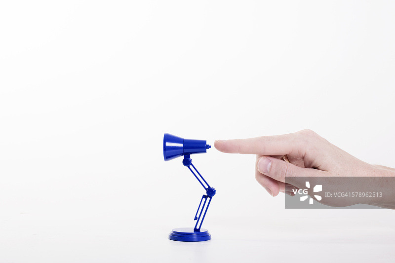 点击微型台灯的手指图片素材