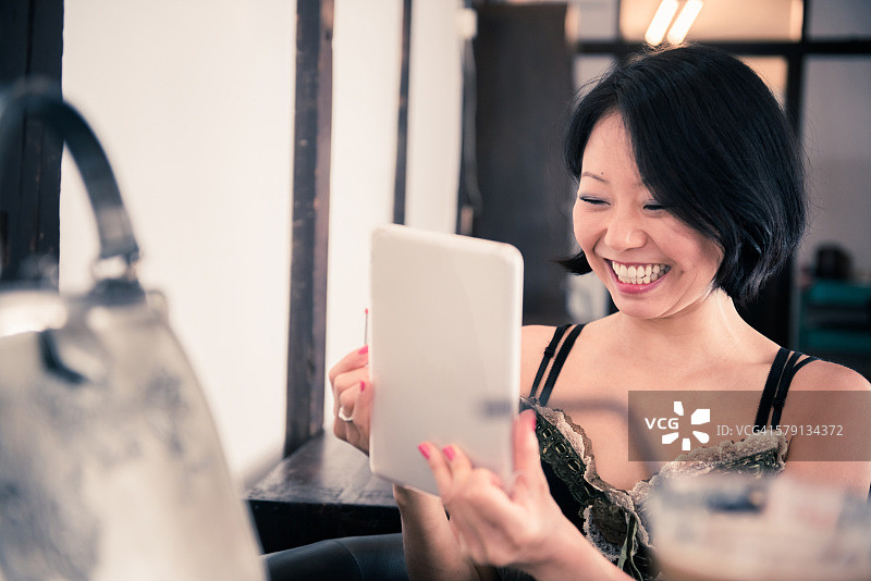 在京都咖啡馆使用平板电脑涂口红的日本女人图片素材