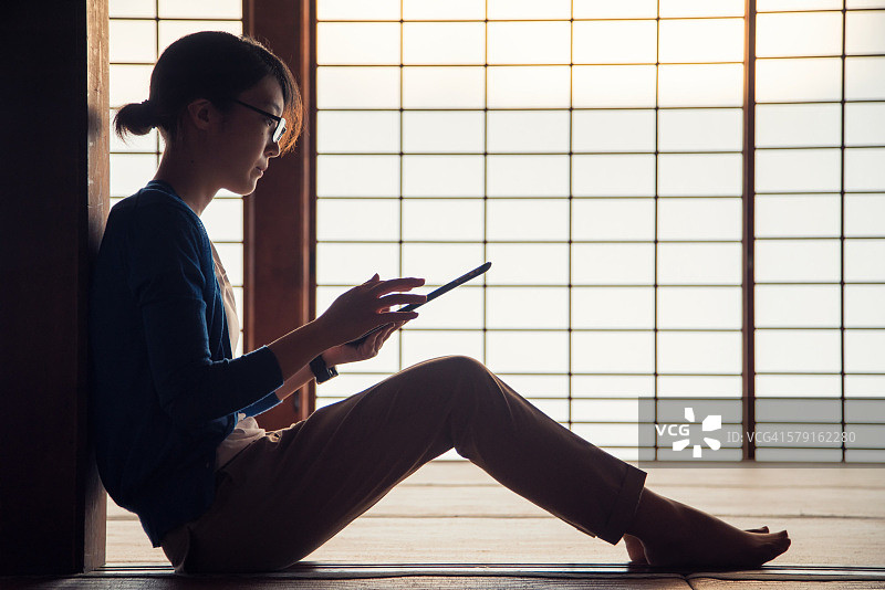 年轻女人阅读平板电脑图片素材