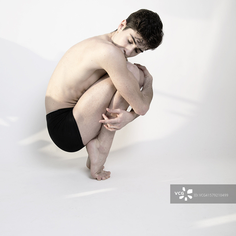 曲膝而坐的男舞者图片素材