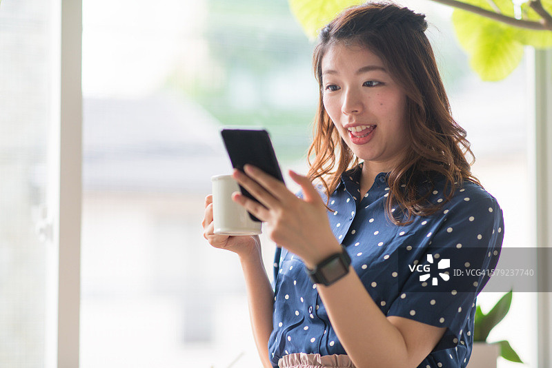 年轻女子正在看她的智能手机图片素材
