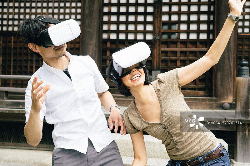 情侣在户外使用虚拟现实模拟器图片素材