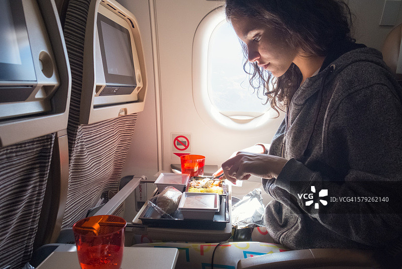 女人在飞机上吃午餐图片素材