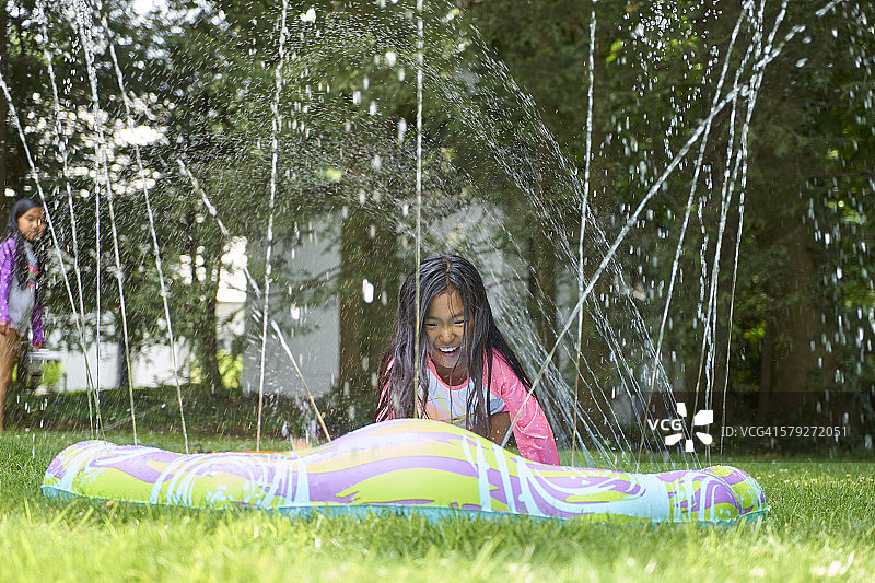 玩滑梯的亚洲双胞胎女孩图片素材