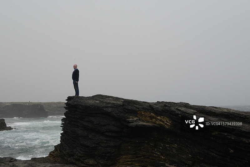 海边岩石上的男子图片素材