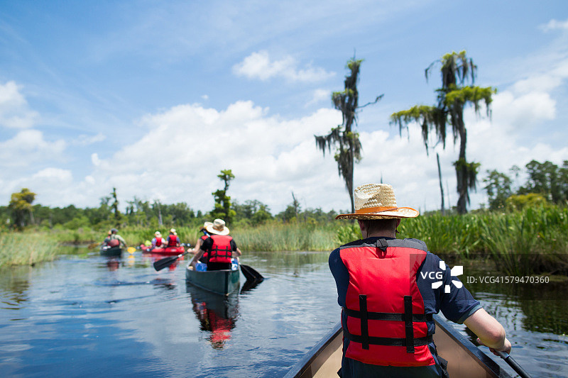 男子在路易斯安那州的湿地划独木舟图片素材