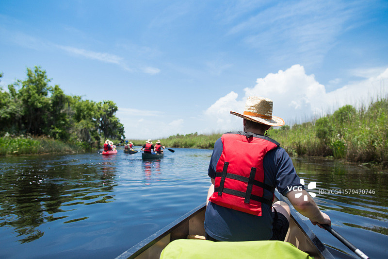 男子在路易斯安那州的湿地划独木舟图片素材