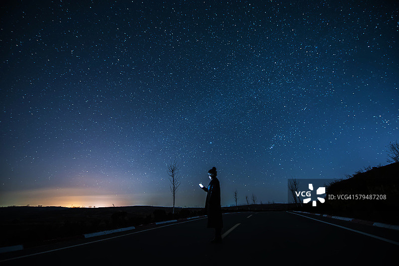 女孩在星夜下使用手机图片素材
