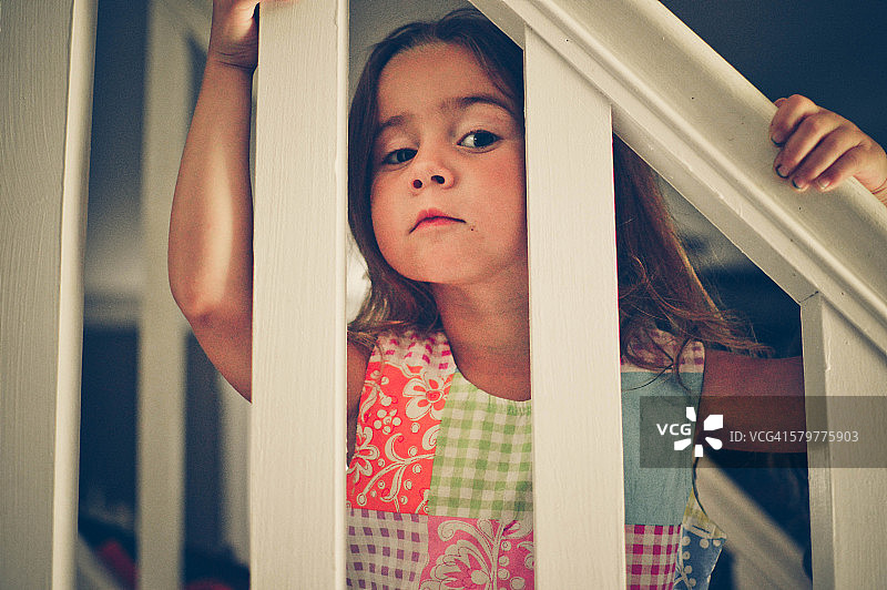 女孩从楼梯栏杆往外看图片素材