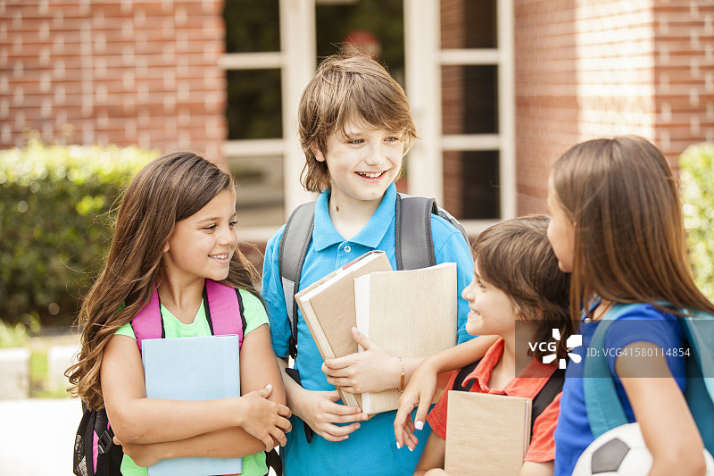 重返校园：小学生和朋友在校园里图片素材
