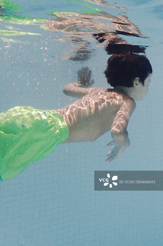 身穿绿色泳衣的儿童水下肖像图片素材
