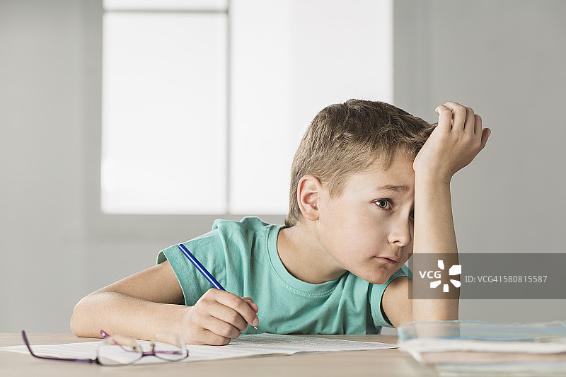 在家做作业感到无聊的男孩图片素材
