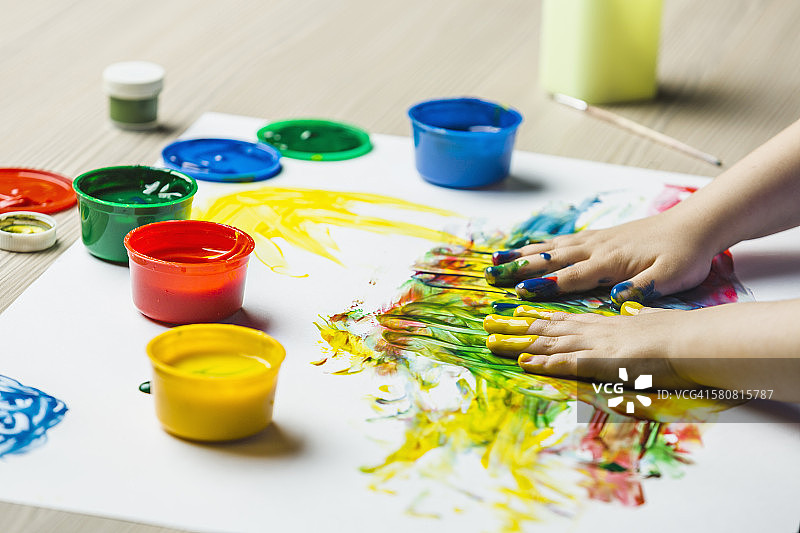 双手在图画纸上进行手指绘画的特写图片素材