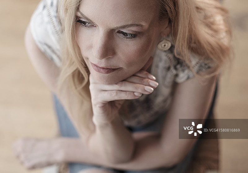 美国新泽西州，坐在椅子上沉思的中年妇女图片素材