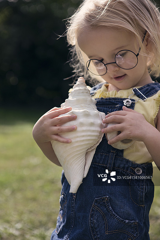 年轻女孩手拿大海螺图片素材