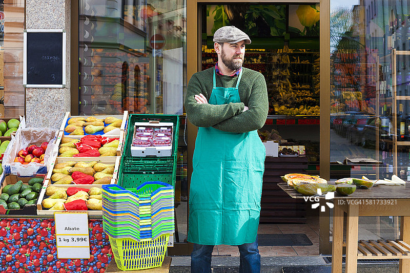 杂货店员在蔬菜店前叉着胳膊图片素材