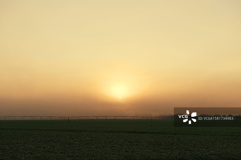 农业：中部大豆田的日出与中心枢轴灌溉系统，美国俄克拉荷马州马斯科吉县。图片素材