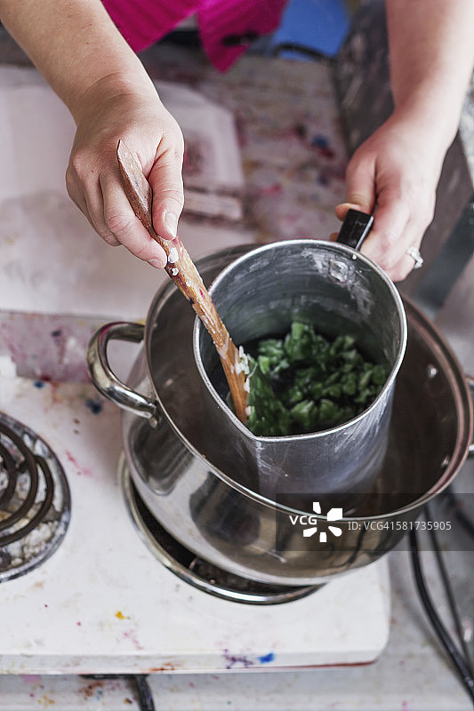 一名女子搅拌热豆蜡，准备手工蜡烛，演示蜡烛制作步骤图片素材