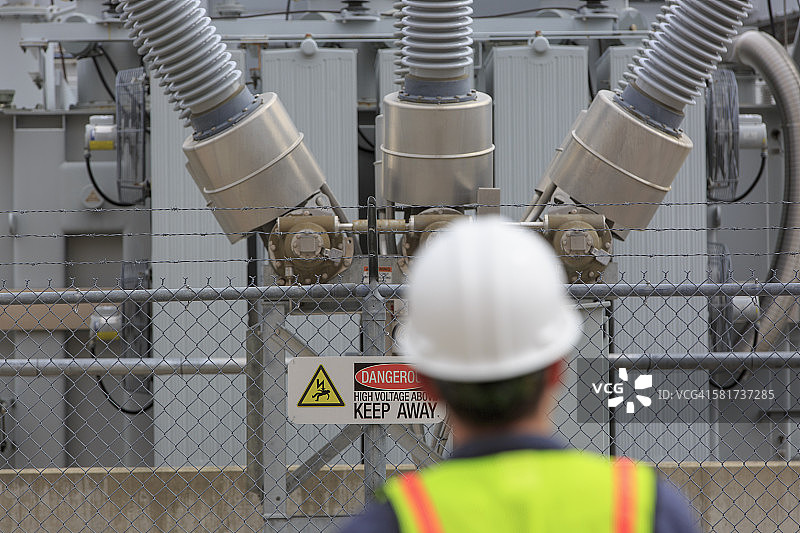 在发电厂检查高压变压器的电力工程师图片素材