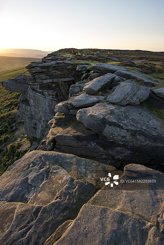 德比郡斯坦尼奇边缘岩石上的金色光芒图片素材