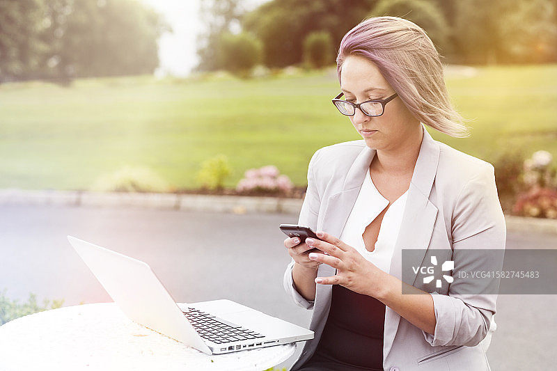 在户外使用智能手机的女人图片素材