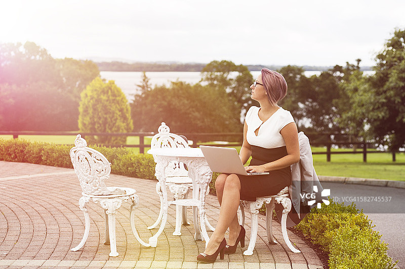在户外使用笔记本电脑工作的女人图片素材