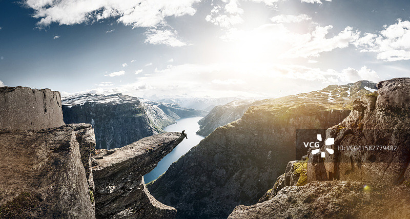 旅行者坐在风景优美的悬崖上图片素材