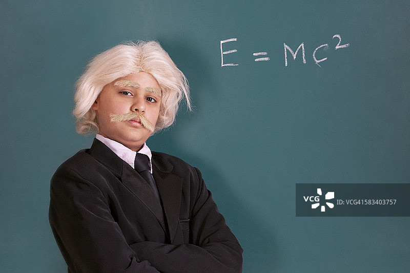 打扮成爱因斯坦并带有数学公式的男孩肖像图片素材