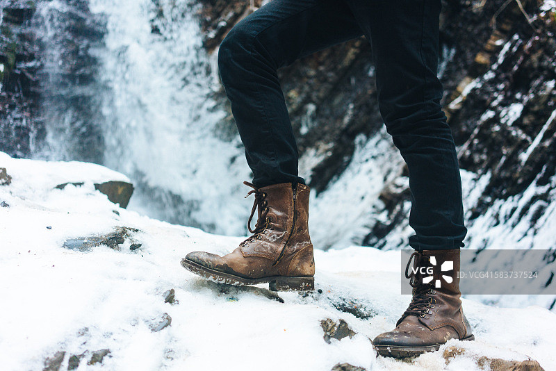 冬季瀑布背景下的靴子图片素材