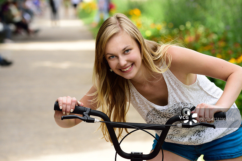 在夏日城市公园骑自行车的女孩图片素材