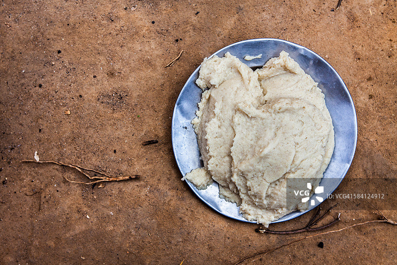 一份sima/ugali，马拉维的主食，在干燥的红色土壤上图片素材