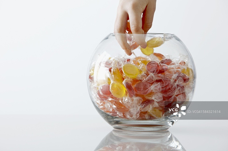 孩子的手伸进糖果罐图片素材