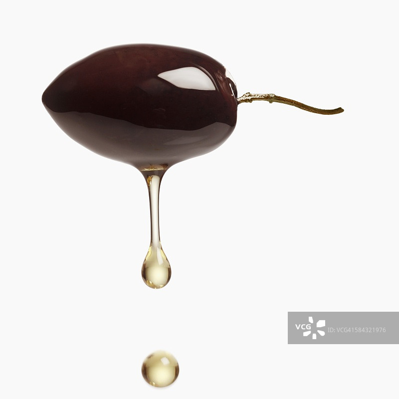 从黑橄榄滴下的橄榄油图片素材