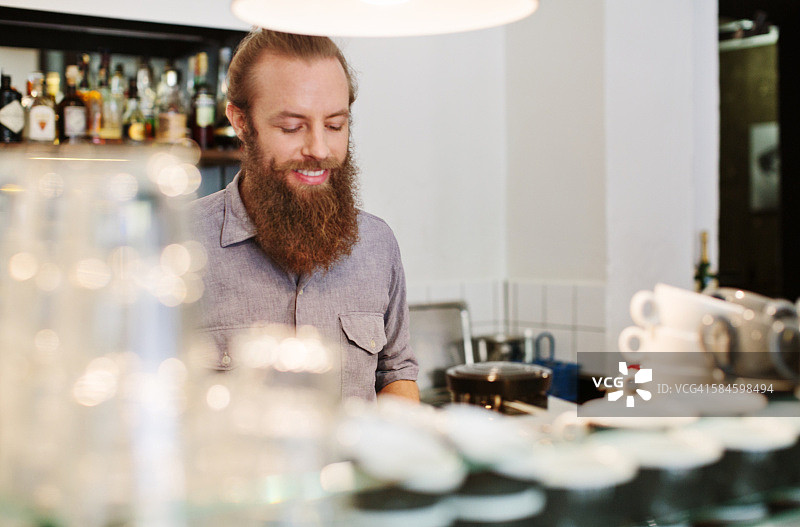 快乐的年轻男子在咖啡馆工作图片素材