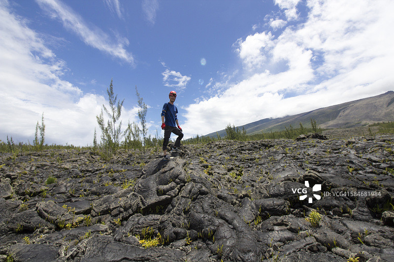 站在留尼汪岛大布雷黑色火山熔岩土壤上的男人图片素材
