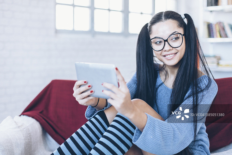 微笑的女学生在家拿着数位板图片素材