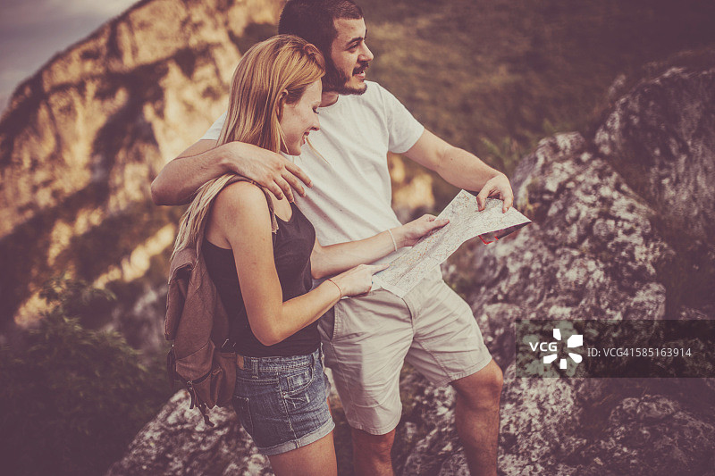 情侣在户外使用地图图片素材
