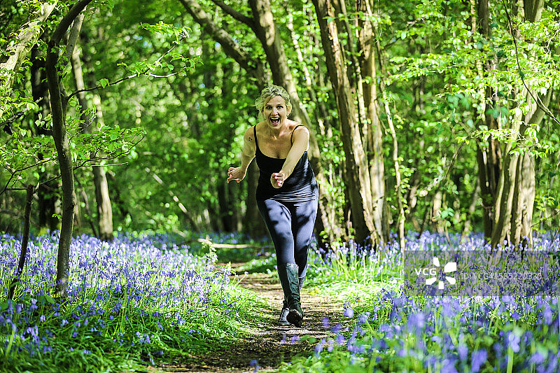 穿梭于风铃木林间的女人图片素材