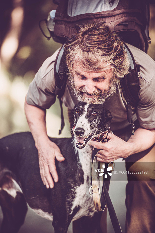 带胡须的年长男人与他的灰狗登山图片素材