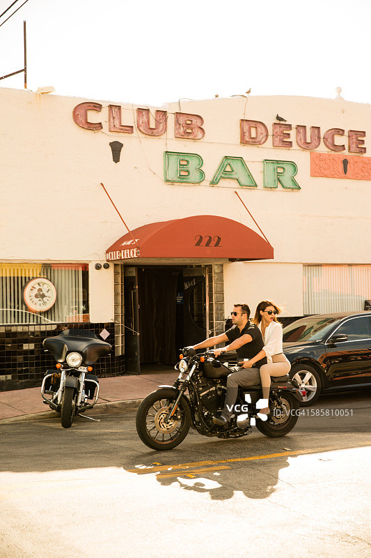 情侣骑摩托车侧面照，美国佛罗里达州迈阿密南海滩图片素材